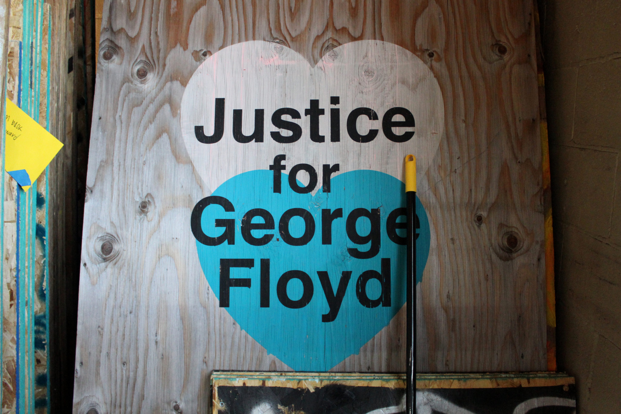 Wooden board with a painted blue and white heart. The words, in black, say Justice for George Floyd